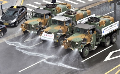 Army vehicles disinfect the road in Daegu about 300 km southeast of Seoul in South Korea